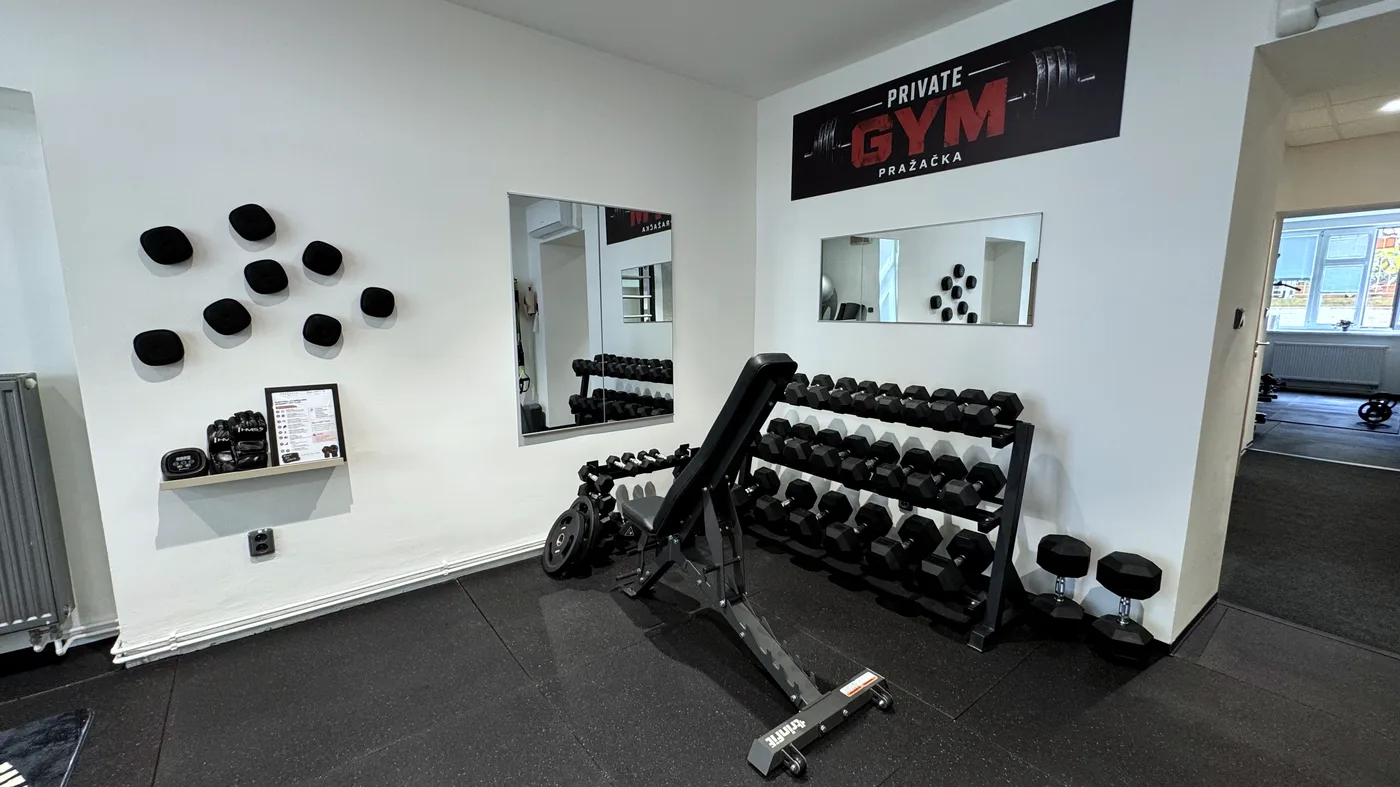 Jednoruční činky a polohovací lavice v posilovně Pražačka Private Gym